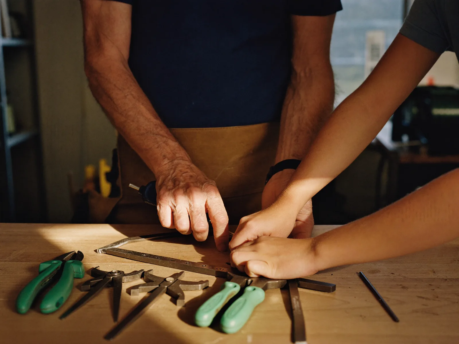 Two generations working together at a workbench